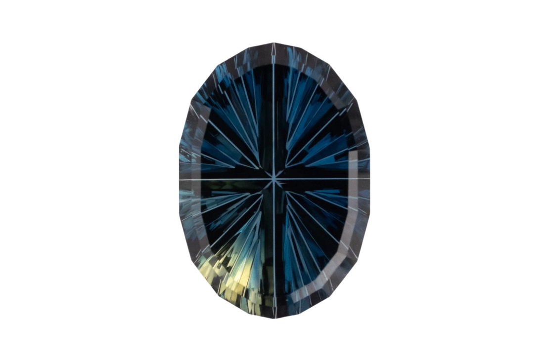 Faceted gemstone with blue and green colors on a white background