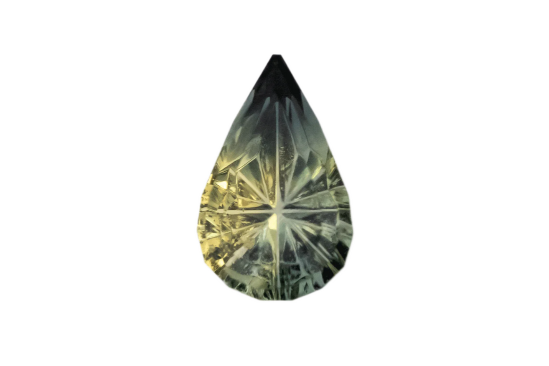 Teardrop-shaped gemstone with a greenish-yellow color on a light gray background