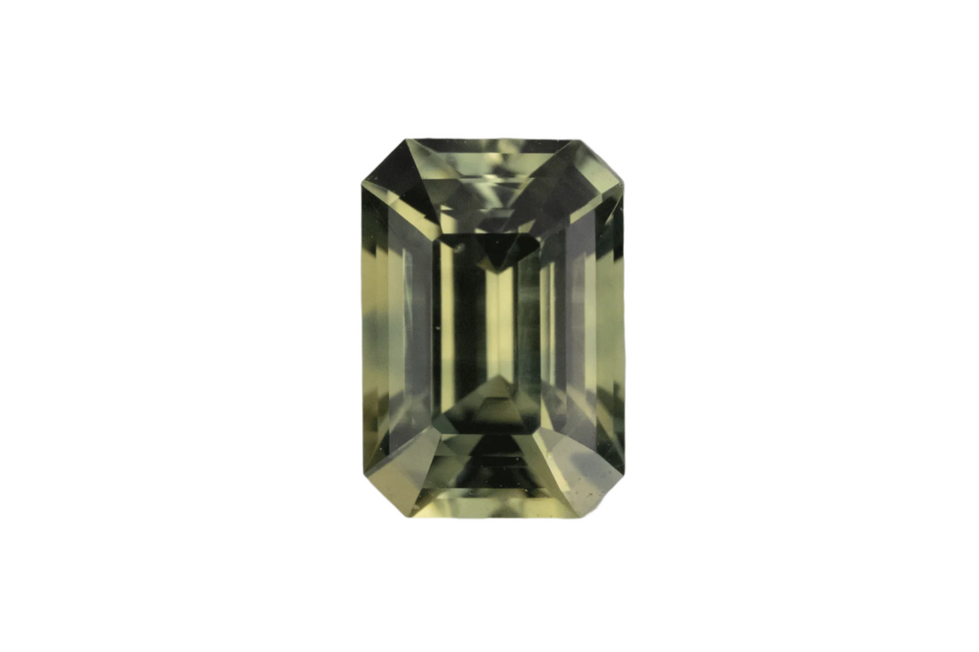 Green gemstone with an emerald cut on a gray background
